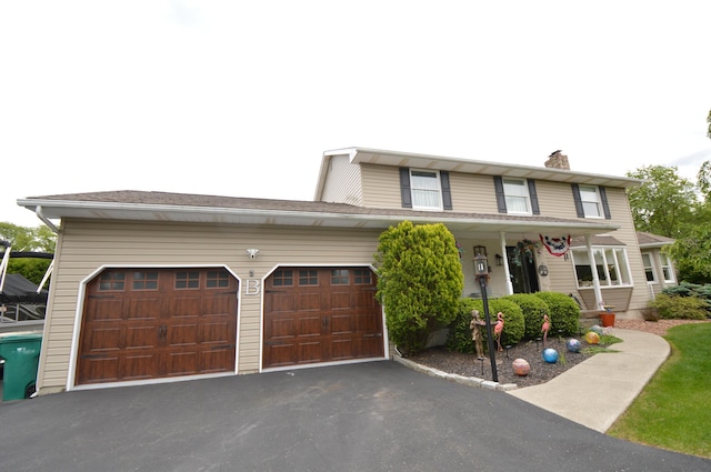 1618 Kickapoo Ter, Effort, PA 18330 - view of front of home with a chimney, asphalt driveway, covered porch, and a garage