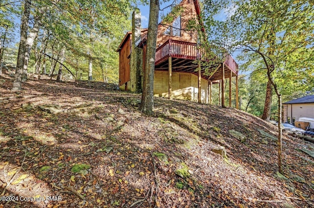 rear view of house featuring a wooden deck