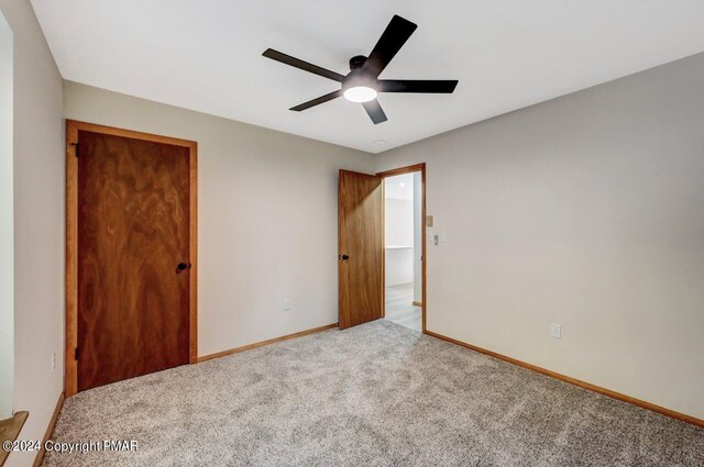 unfurnished bedroom featuring a ceiling fan, a closet, baseboards, and carpet flooring
