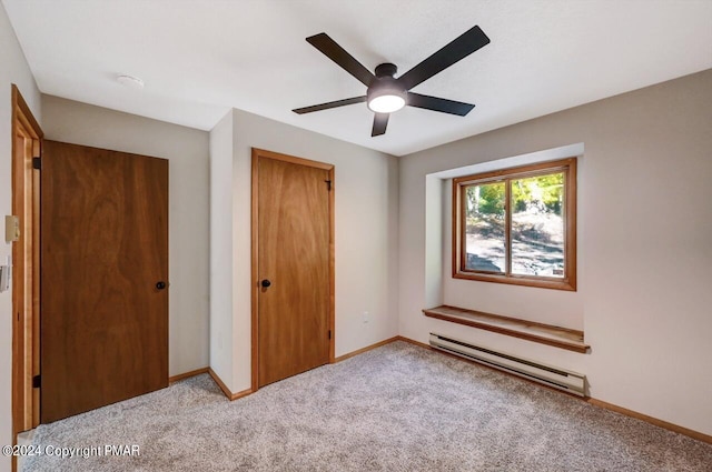 unfurnished bedroom featuring carpet floors, a closet, a baseboard heating unit, a ceiling fan, and baseboards