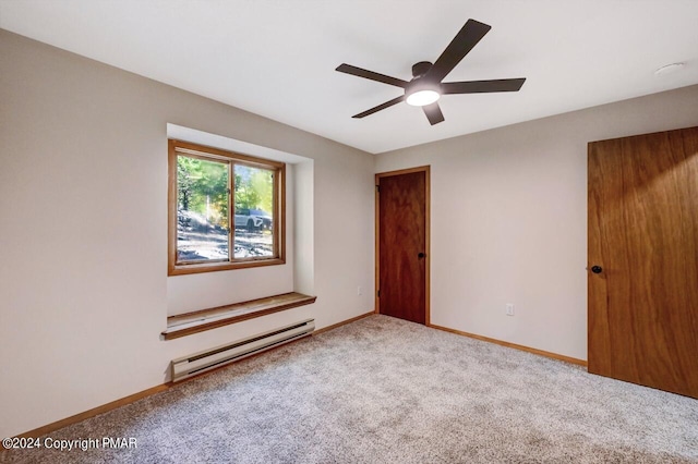 empty room featuring baseboard heating, carpet flooring, a ceiling fan, and baseboards