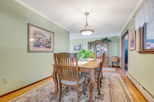 148 Summit Ave, Pocono Summit, PA 18346 - dining space featuring crown molding, baseboards, light wood-style flooring, and a baseboard radiator