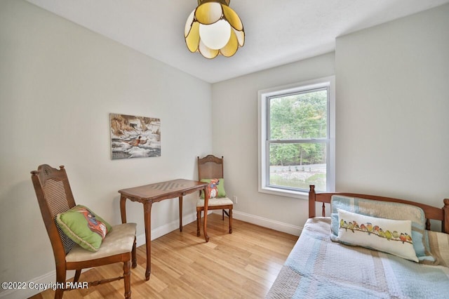 bedroom with light wood finished floors and baseboards