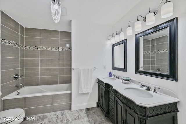 full bath featuring marble finish floor, toilet, double vanity, and a sink