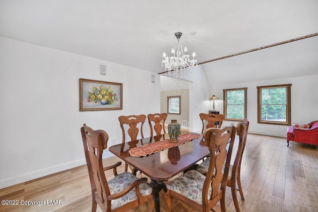 dining room with a chandelier, visible vents, light wood-style flooring, and baseboards
