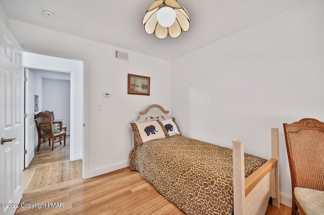bedroom featuring baseboards, visible vents, and light wood-type flooring
