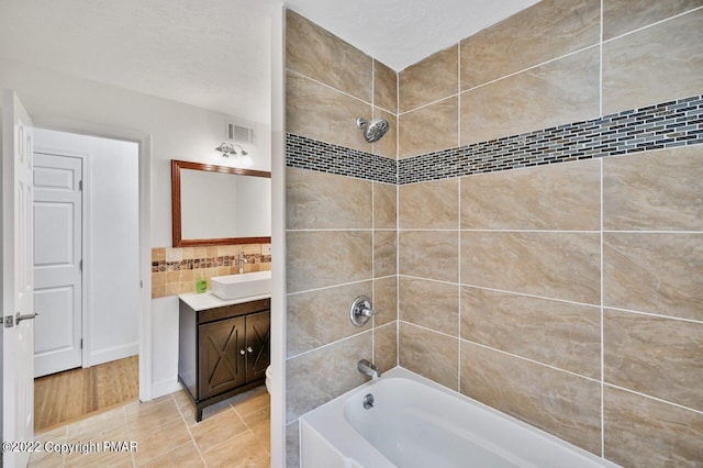 bathroom featuring tile patterned flooring, shower / bathtub combination, vanity, and visible vents
