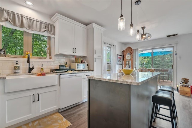 2218 Lancaster Dr, Lehman, PA 18324 - kitchen featuring white appliances, decorative backsplash, white cabinets, a kitchen island, and wood finished floors