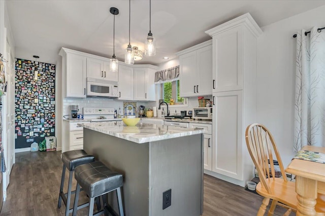 2218 Lancaster Dr, Lehman, PA 18324 - kitchen featuring white appliances, white cabinetry, dark wood finished floors, and a breakfast bar area