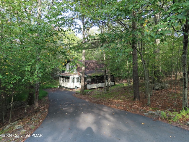 view of front facade featuring a sunroom and aphalt driveway