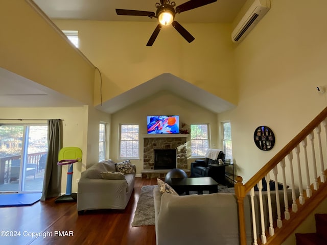 living room featuring stairs, a wall unit AC, plenty of natural light, and wood finished floors