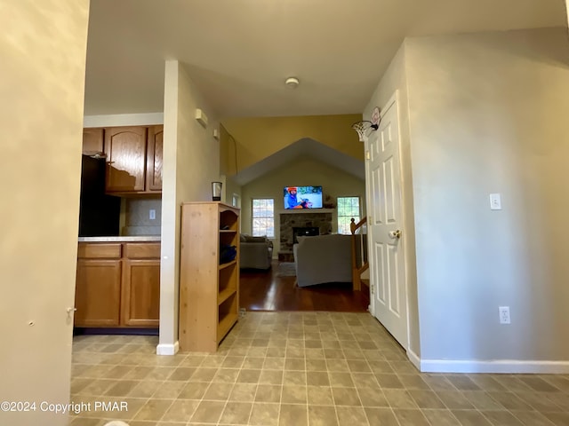 hall with lofted ceiling and baseboards