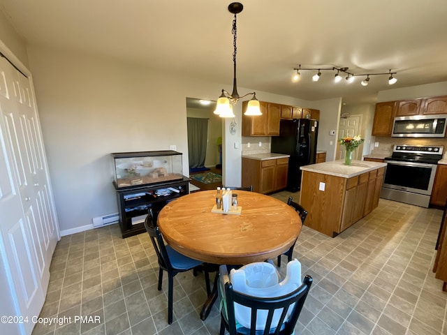 kitchen featuring stainless steel appliances, light countertops, baseboard heating, decorative backsplash, and a center island