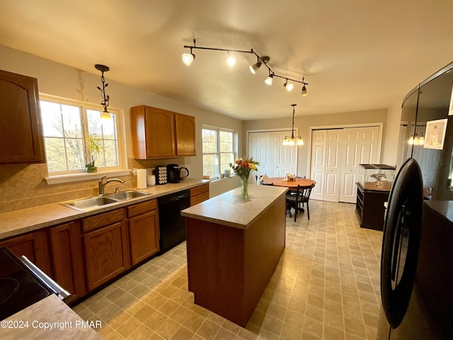 kitchen with black appliances, brown cabinetry, a sink, and light countertops