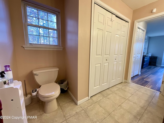 bathroom with toilet, tile patterned flooring, and baseboards