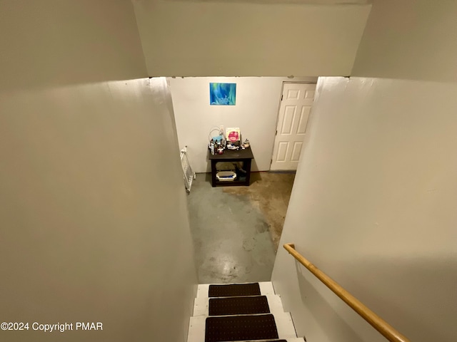 stairs with unfinished concrete flooring