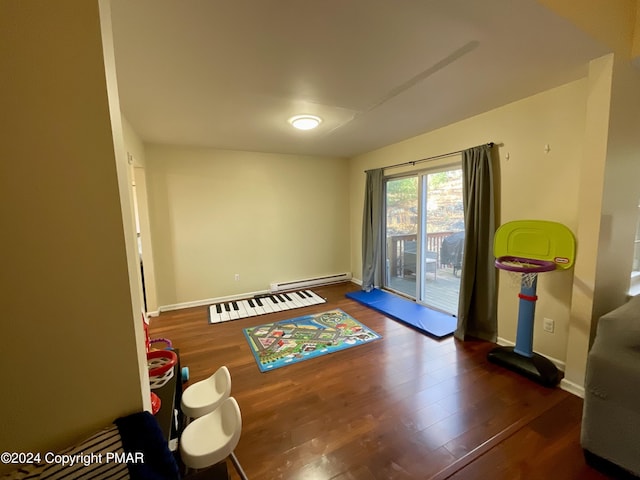 interior space featuring baseboard heating, wood finished floors, and baseboards