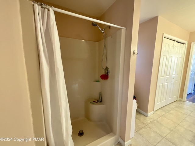 full bathroom featuring a stall shower, baseboards, and tile patterned floors