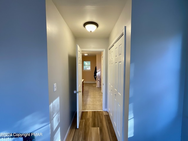 hall with baseboard heating, baseboards, and dark wood finished floors