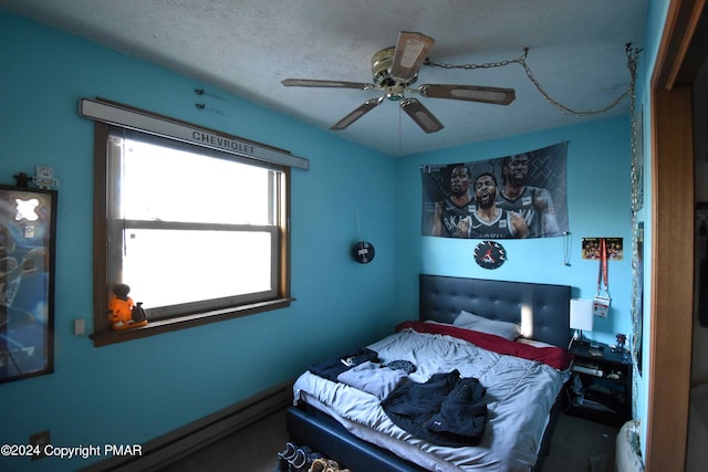 bedroom featuring a baseboard radiator, ceiling fan, and a textured ceiling