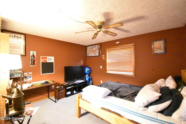 carpeted bedroom featuring a ceiling fan and a textured ceiling