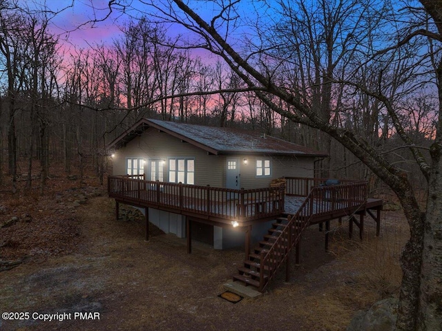 9871 Deerwood Dr, Tobyhanna, PA 18466 - back of property at dusk featuring a deck and stairway