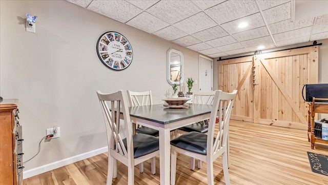 3954 Cedar Dr, Walnutport, PA 18088 - dining area with a barn door, light wood-type flooring, and a drop ceiling