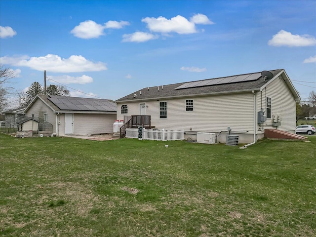 3954 Cedar Dr, Walnutport, PA 18088 - rear view of property featuring solar panels, a lawn, a deck, and an outbuilding