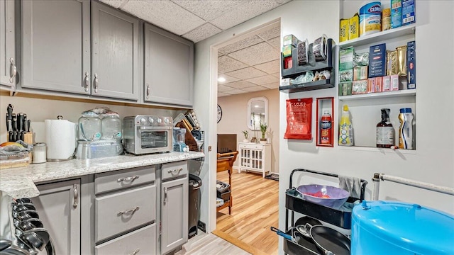 3954 Cedar Dr, Walnutport, PA 18088 - kitchen featuring a paneled ceiling, gray cabinets, light wood finished floors, and open shelves