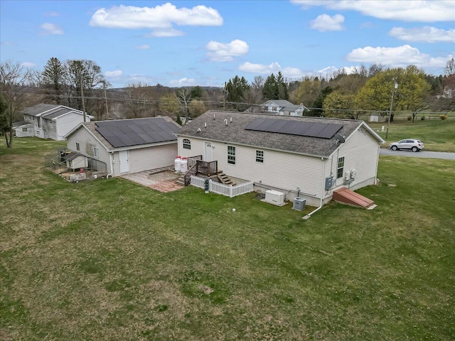 3954 Cedar Dr, Walnutport, PA 18088 - rear view of property with solar panels, a shingled roof, a yard, and a deck