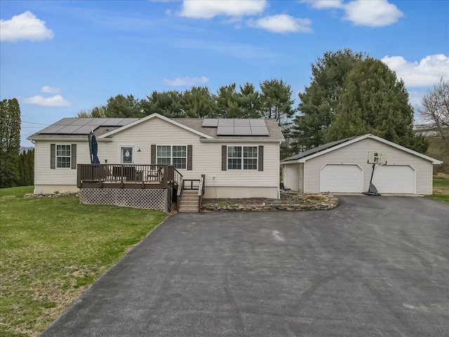 3954 Cedar Dr, Walnutport, PA 18088 - view of front of house with a detached garage, a front yard, an outdoor structure, a wooden deck, and solar panels