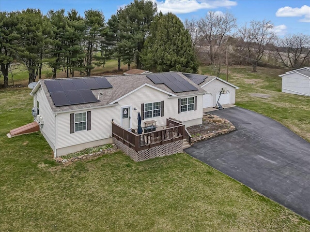 3954 Cedar Dr, Walnutport, PA 18088 - back of house with roof with shingles, a lawn, a deck, roof mounted solar panels, and a detached garage