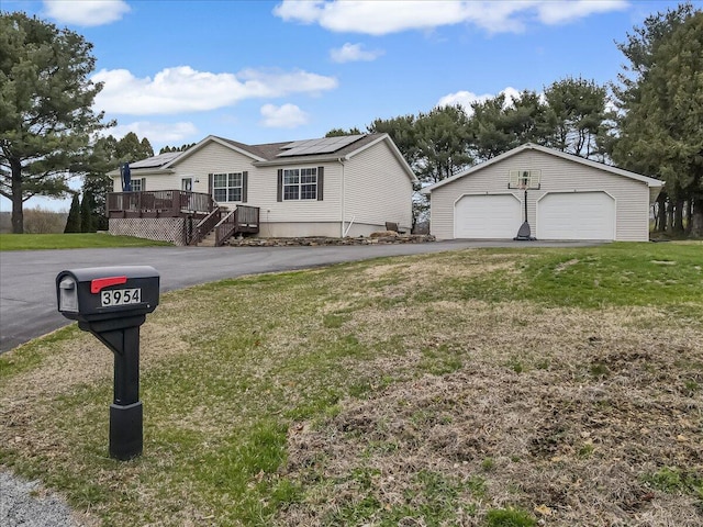 3954 Cedar Dr, Walnutport, PA 18088 - view of front facade with a garage, a wooden deck, a front yard, an outdoor structure, and solar panels