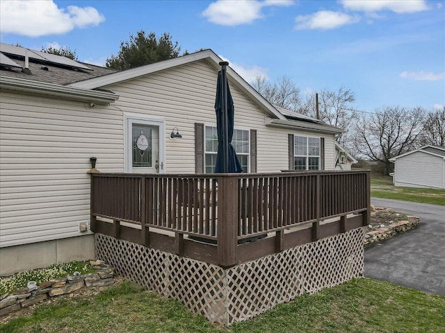 3954 Cedar Dr, Walnutport, PA 18088 - back of property with a wooden deck, roof with shingles, and solar panels