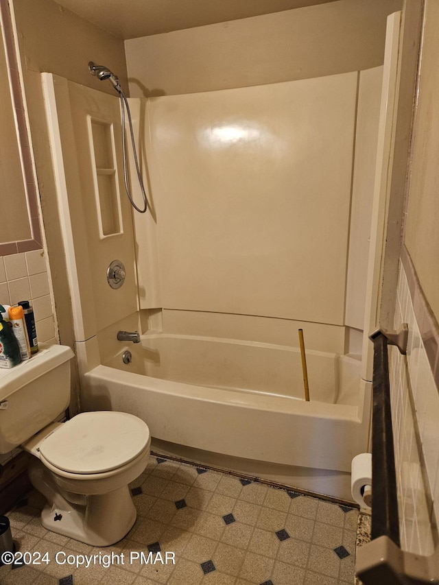 bathroom with  shower combination, toilet, and tile patterned floors