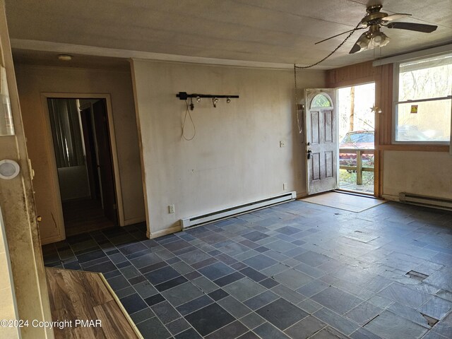 spare room with stone tile floors, a baseboard heating unit, and ceiling fan