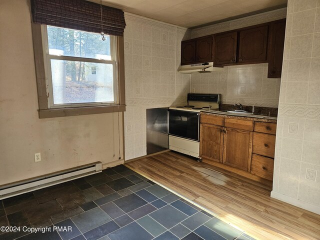 kitchen featuring under cabinet range hood, baseboard heating, dark wood-style flooring, electric stove, and a sink