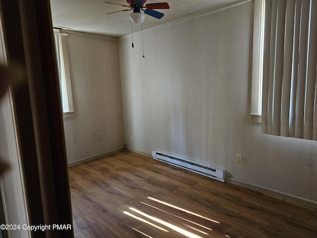 spare room with baseboards, a baseboard heating unit, ceiling fan, and wood finished floors