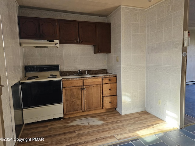 kitchen with tile walls, light wood finished floors, white electric range, and under cabinet range hood