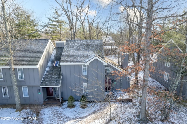 exterior space with board and batten siding and a chimney