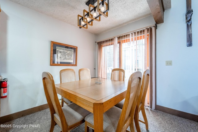 dining room featuring a textured ceiling and baseboards