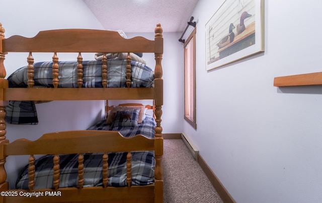 carpeted bedroom with a textured ceiling, a baseboard radiator, and baseboards