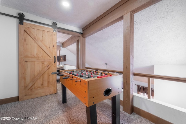 rec room featuring carpet flooring, a textured ceiling, lofted ceiling with beams, and a barn door