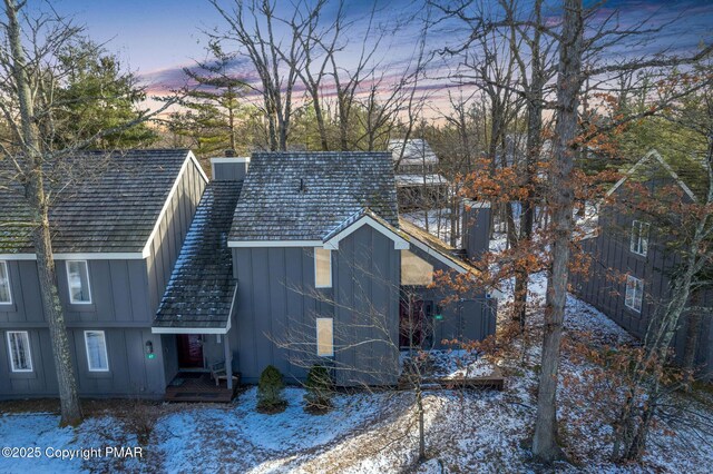 exterior space featuring board and batten siding and a chimney