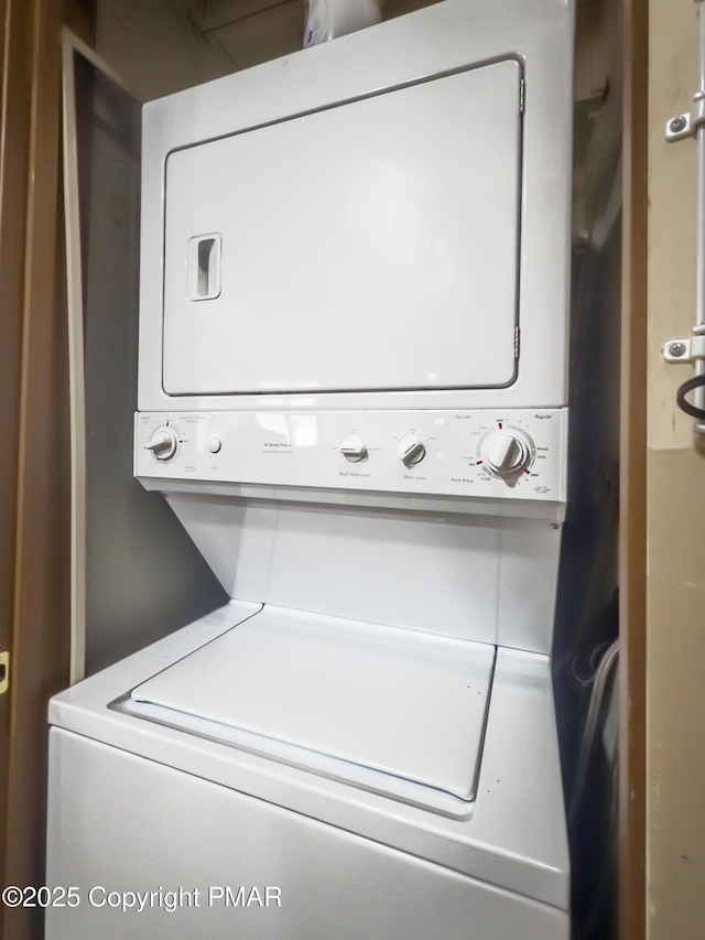 clothes washing area featuring laundry area and stacked washer / dryer