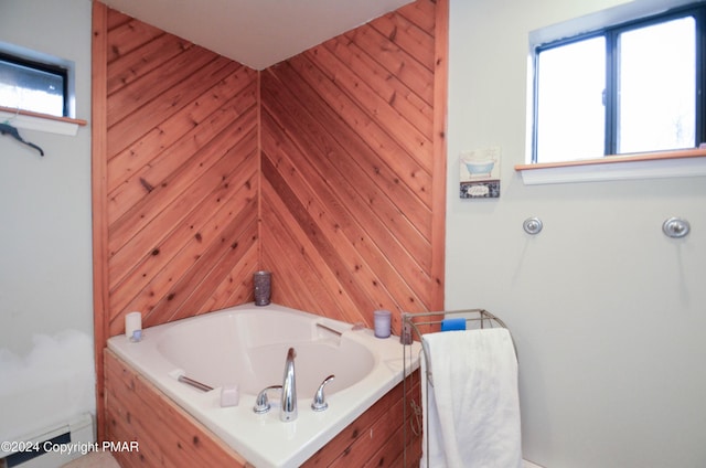 bathroom with a garden tub and baseboard heating