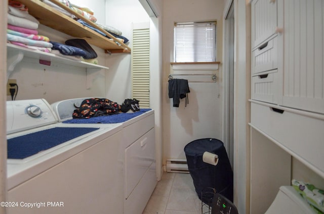 clothes washing area featuring laundry area, light tile patterned floors, washing machine and dryer, and a baseboard radiator