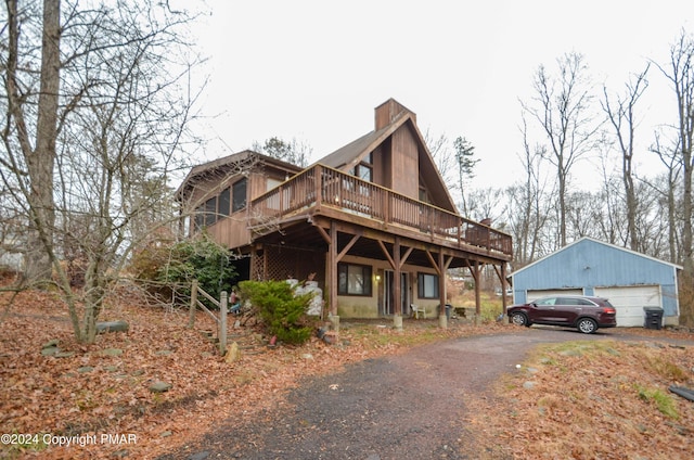 view of front facade with a garage, an outbuilding, and a deck