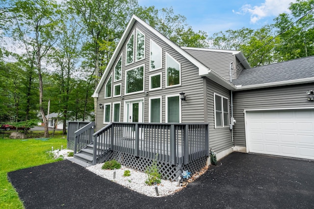4130 Mill Creek Dr, Cresco, PA 18326 - chalet / cabin featuring a deck, an attached garage, a front lawn, and asphalt driveway