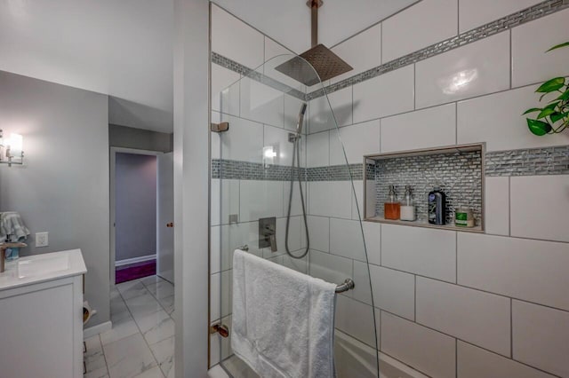 bathroom featuring vanity, tiled shower, and marble finish floor